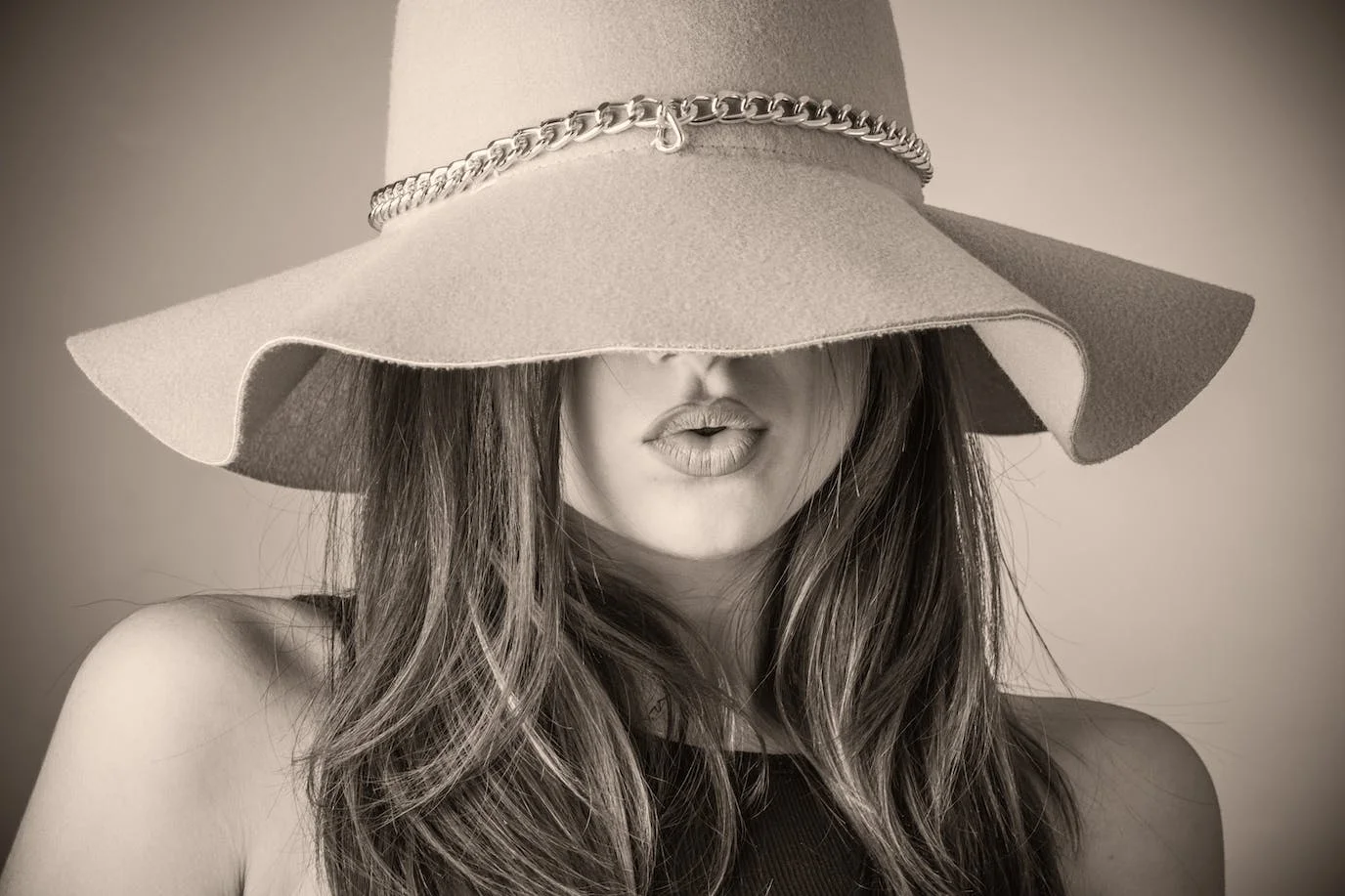 Woman photo : black and white/sepia photography of a long-haired woman wearing a hat.